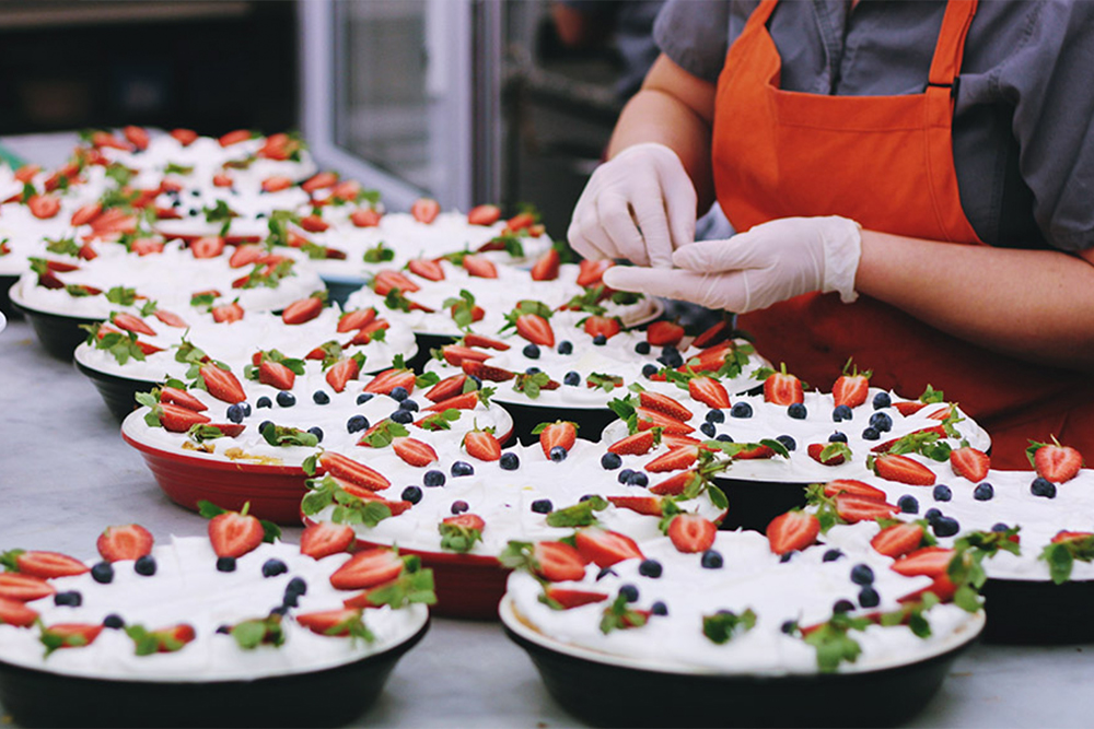 Someone plating a fruit dish at a restaurant