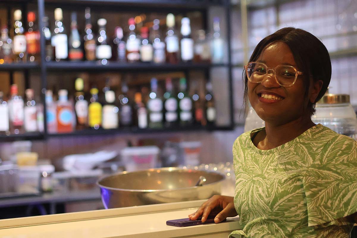 A smiling woman sitting at a bar